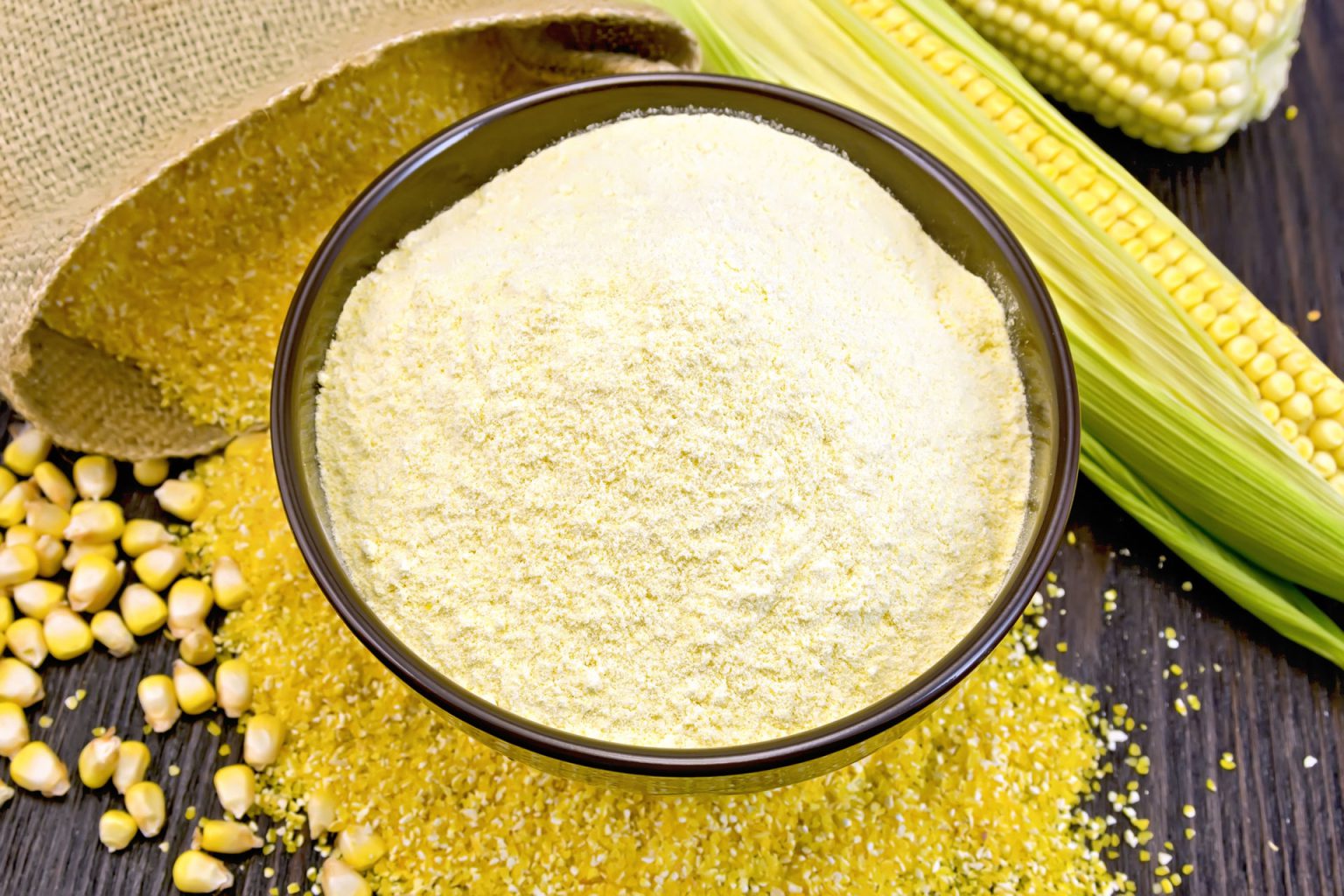flour corn in bowl with grits and cob on dark boar